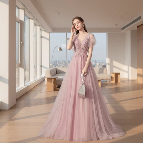 Woman in a pink evening gown against a textured gray wall