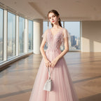 Woman in a pink evening gown holding a fan against a gray textured wall