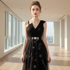Woman wearing a black evening gown with silver embroidery on a white background