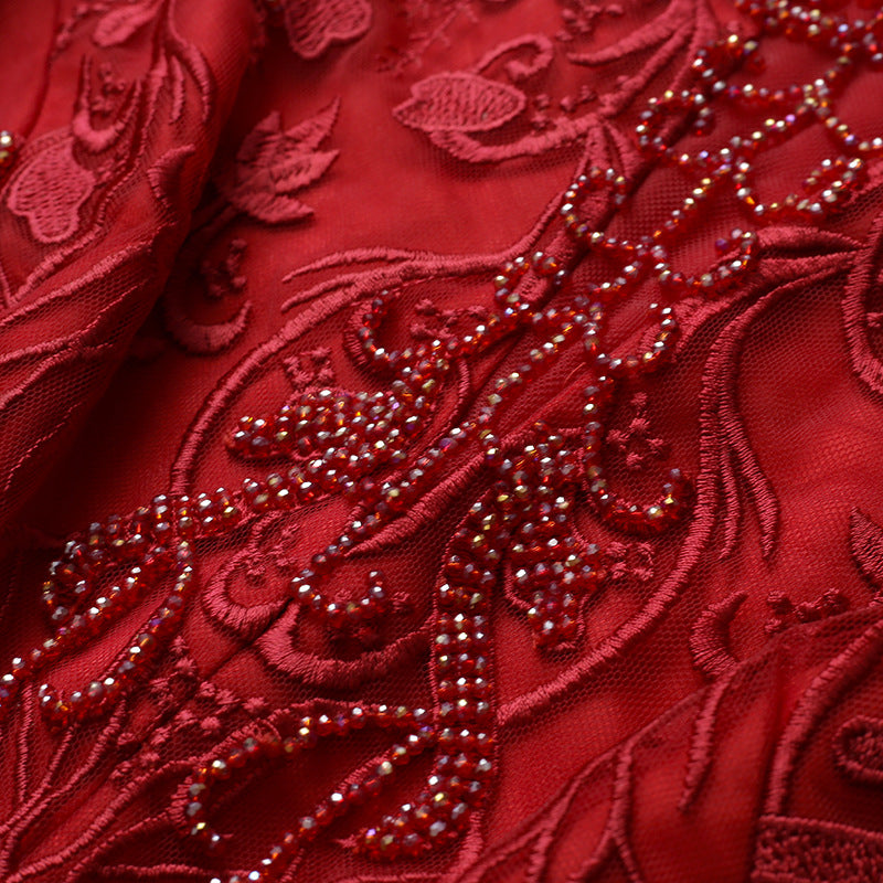 Close-up of red embroidered fabric with intricate patterns and beads