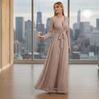 Woman wearing a long, flowing dress in a room with white walls and a small table.