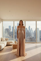 Elegant off-shoulder gown with a high slit on a gray background